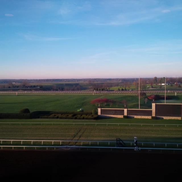 the view of a large green field from a building on a hill