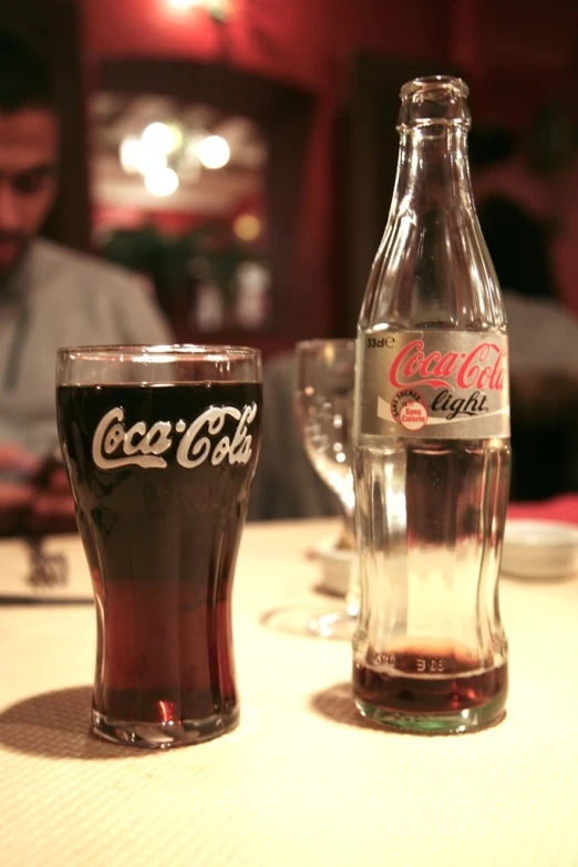 two glasses sitting next to a bottle and a glass