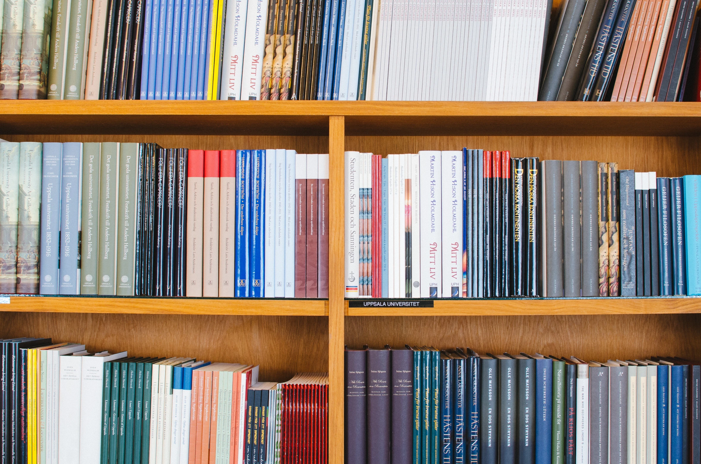 a close up s of books on wooden shelves