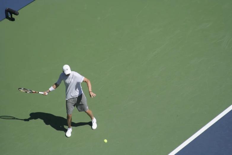 man playing tennis and looking at ball, on court