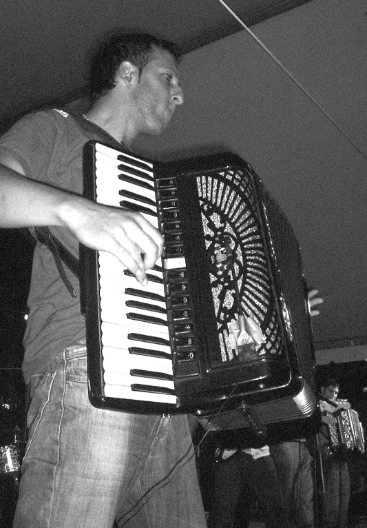 a man holding an accordion with its mouth open