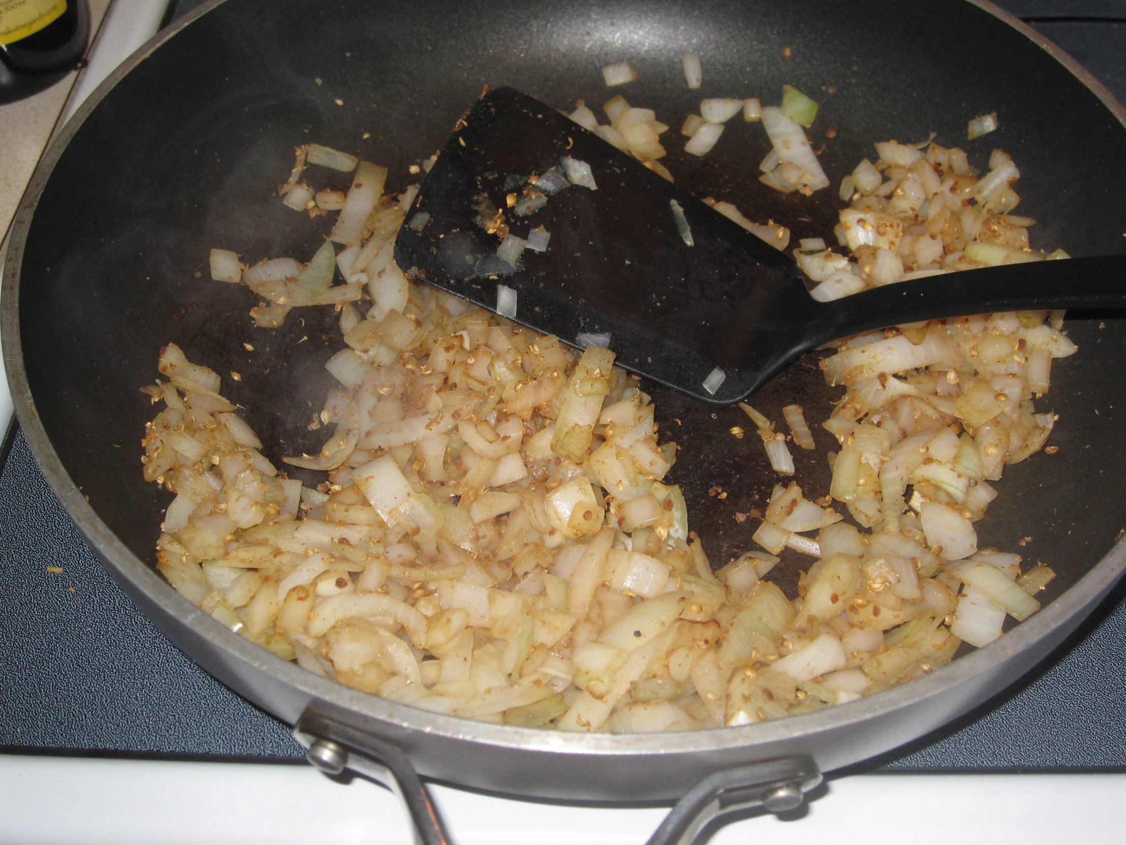 onions and a spoon in a pan on a stove