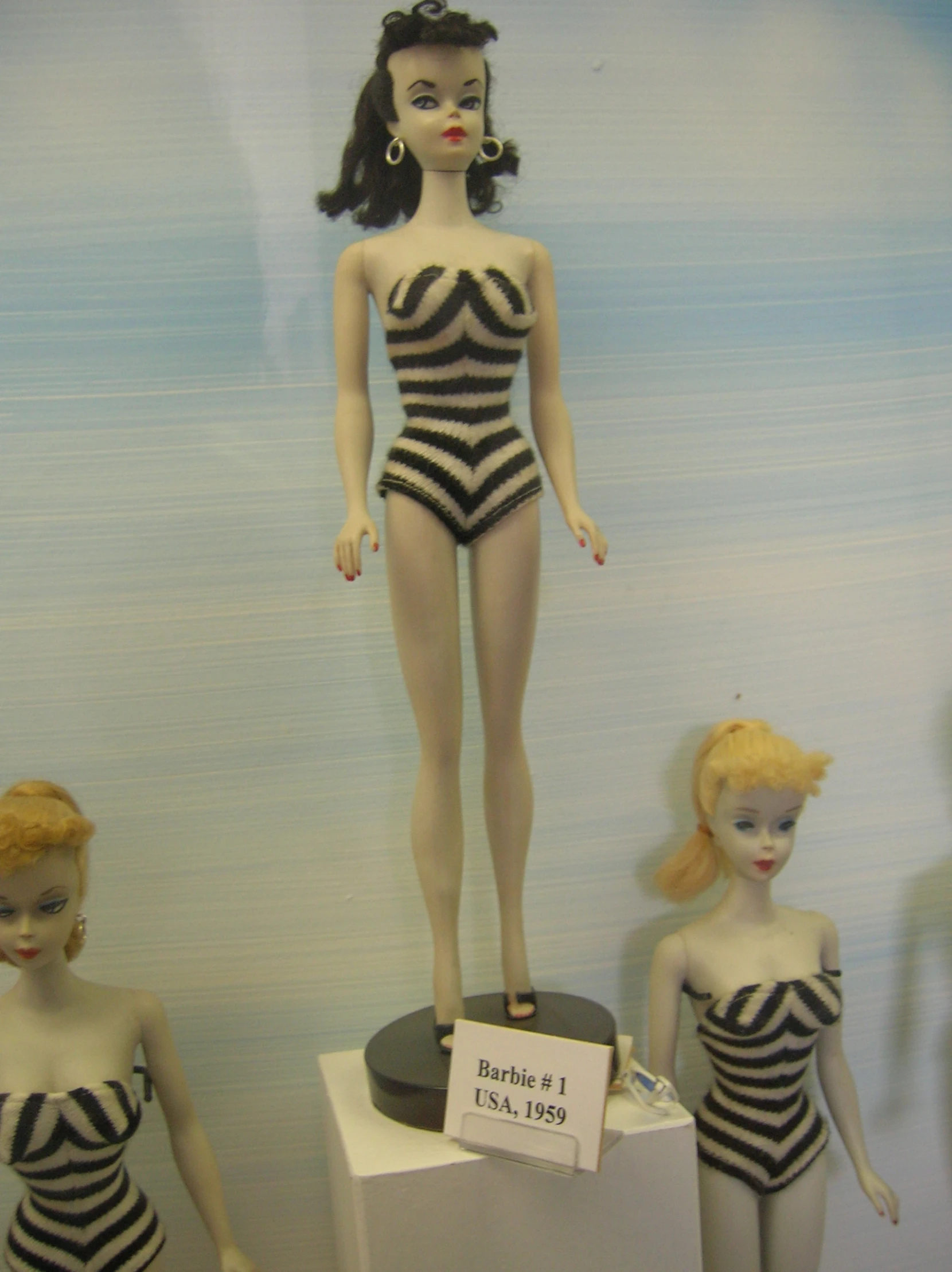dolls are lined up on display, in a room