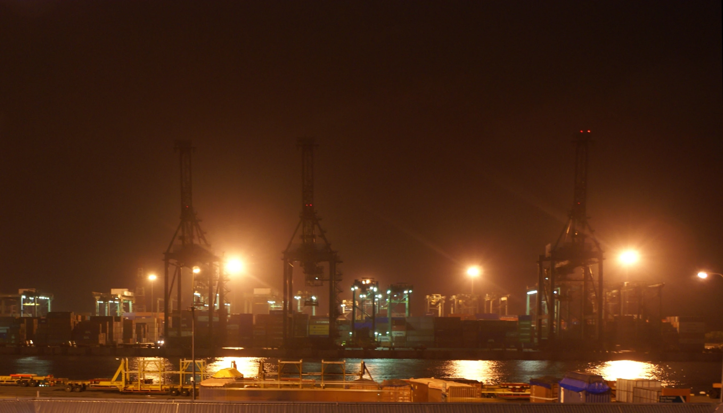 a harbor at night with several boats docked in it