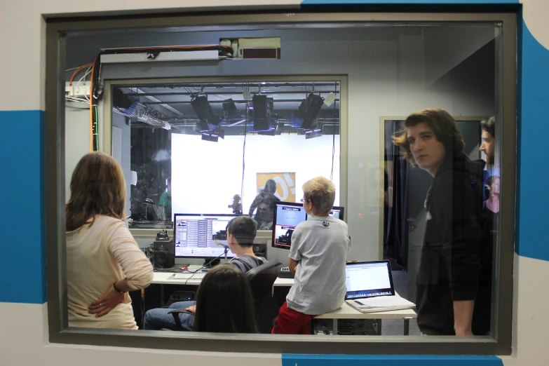 a mirror showing several people working on computers