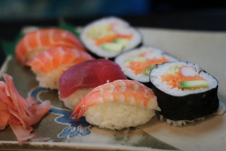 a plate with sushi and flowers next to it