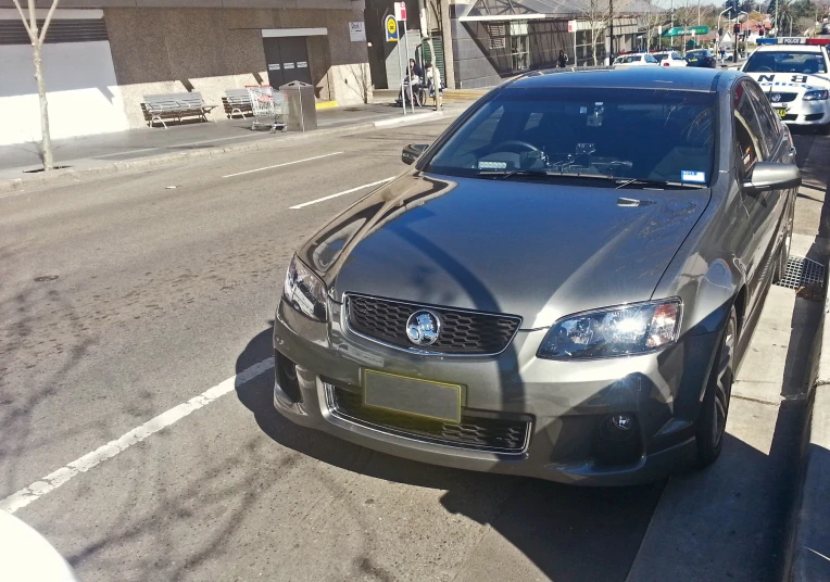 the silver car is parked on the street