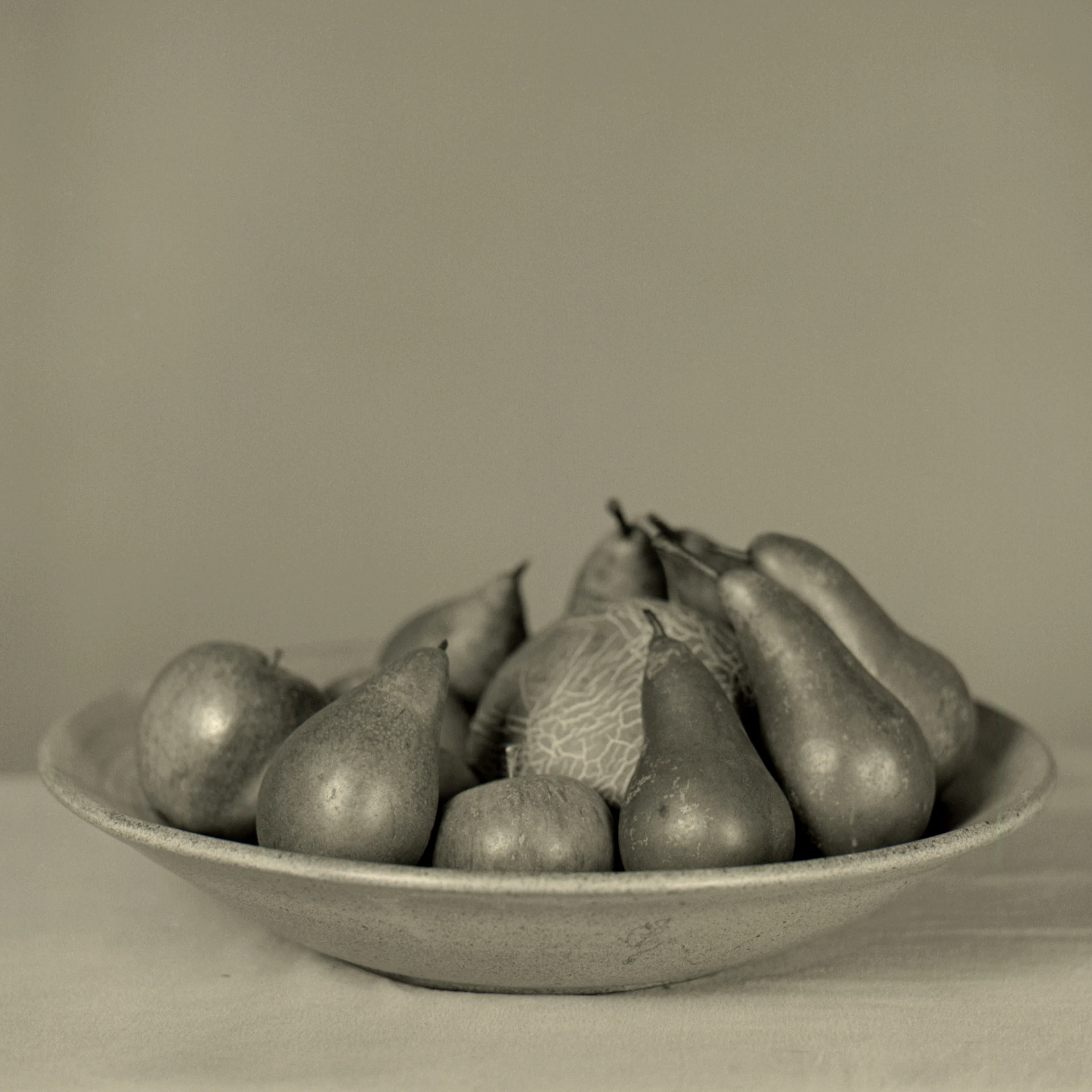 some pears are arranged in a white bowl