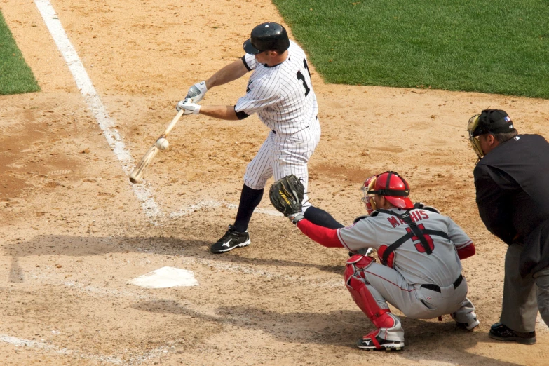 a baseball player swinging a bat over home plate