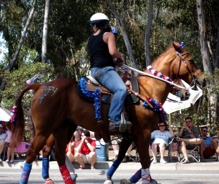 a woman riding on the back of a brown horse