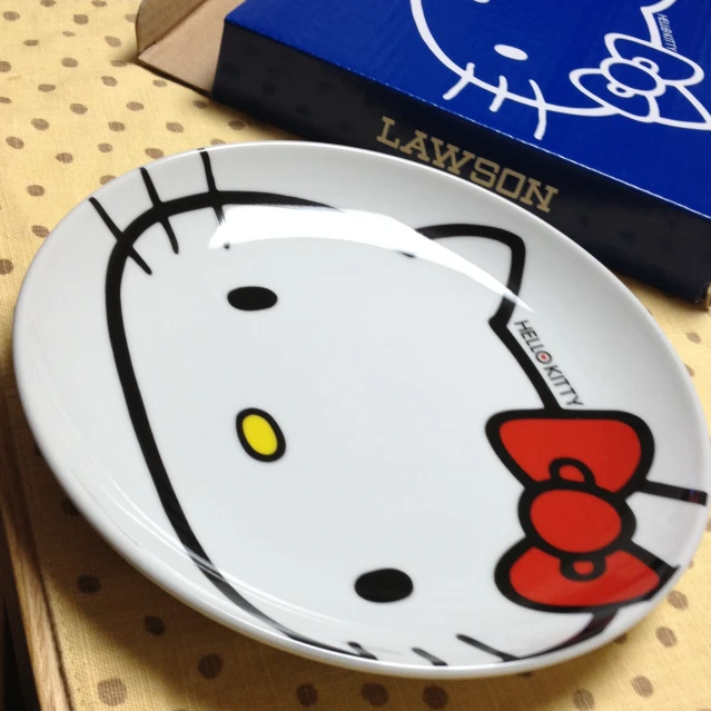 a plate with hello kitty on it is sitting next to a box