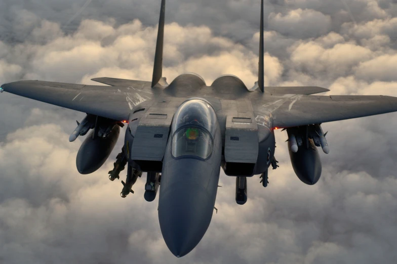 the front of a fighter jet in flight on a cloudy day