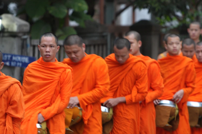 a group of men in orange robes playing drums