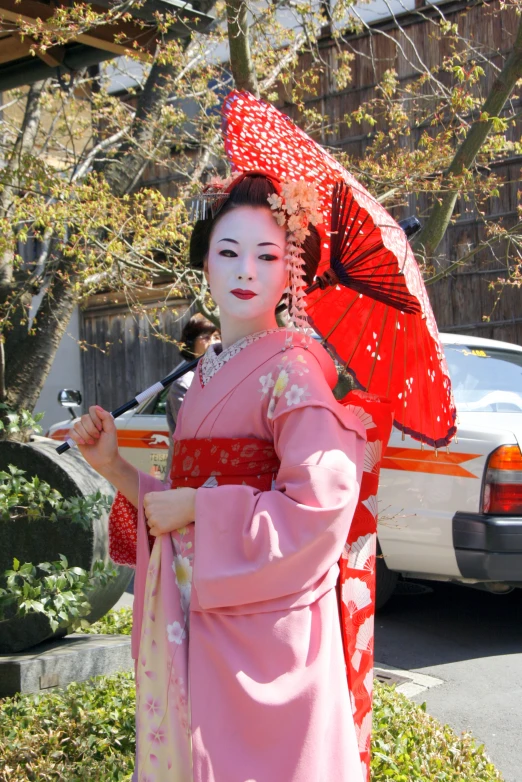 a woman in japanese attire holding an umbrella