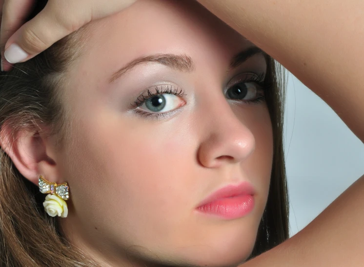 a girl wearing a earrings posing for the camera