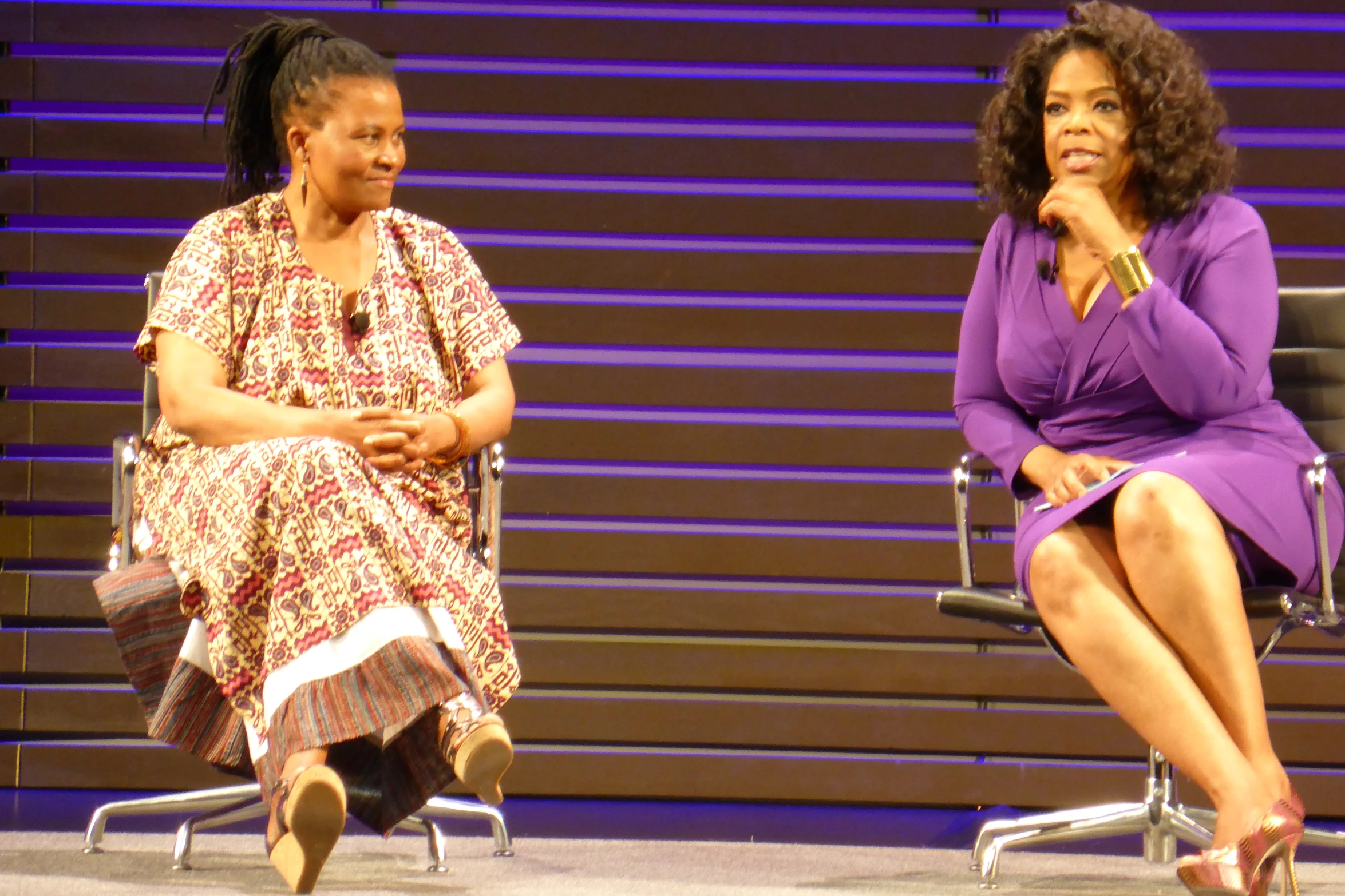 two women sit on chairs as they talk