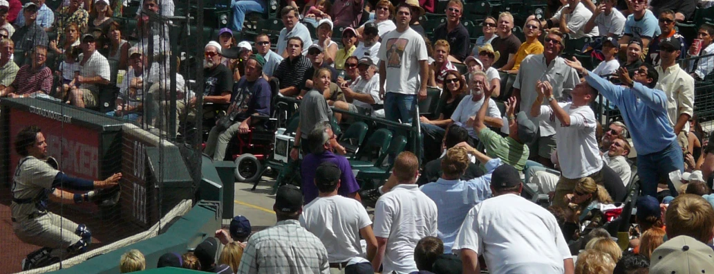 a crowd of people at a tennis game, some with shoes in the air