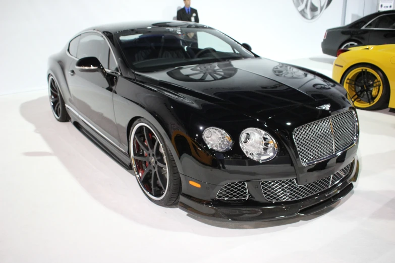 a black bentley sitting on display in a building