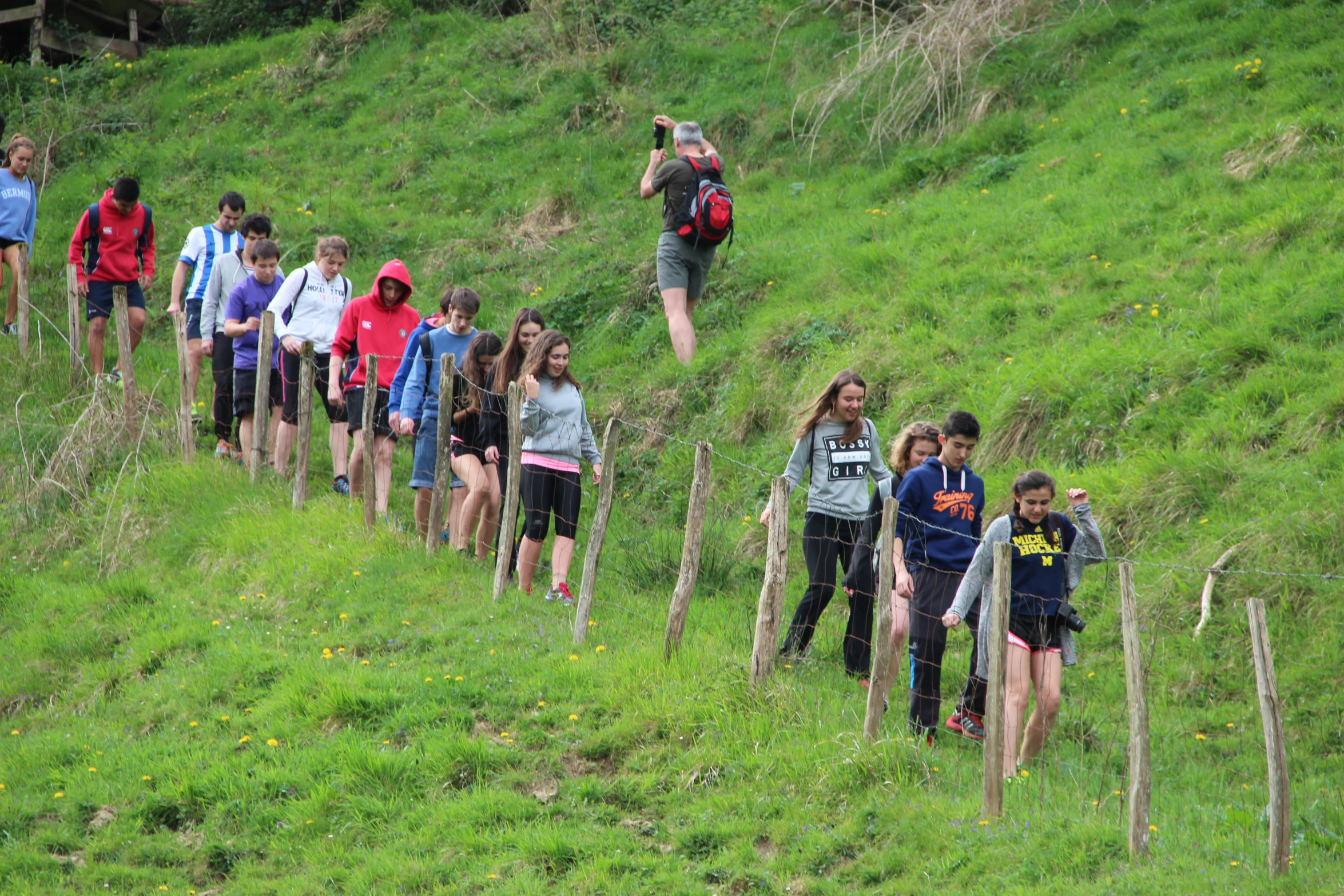 many people on a hill and one of them is carrying luggage