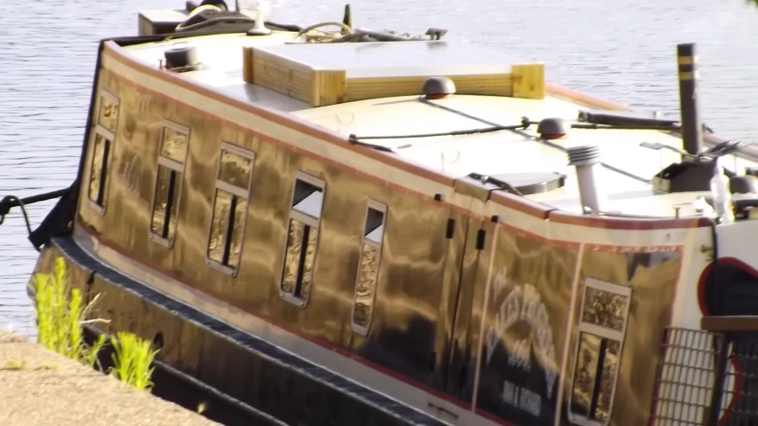 a barge is sitting by the shore near water