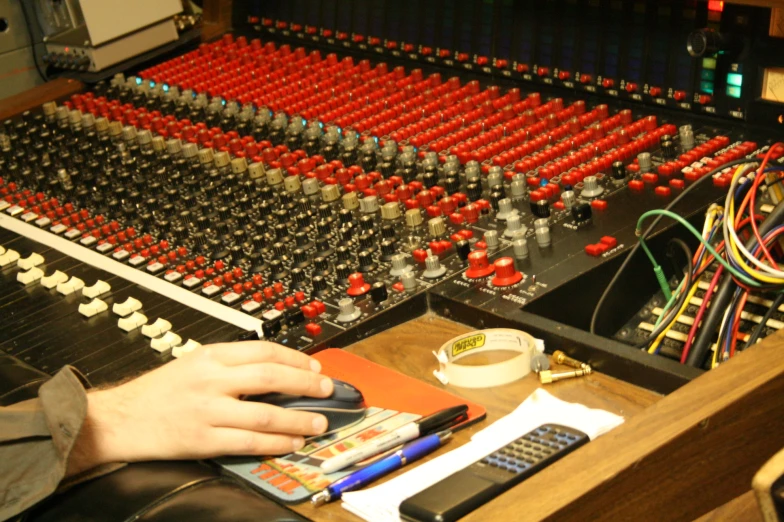 the mixer board is full of music mixing equipment
