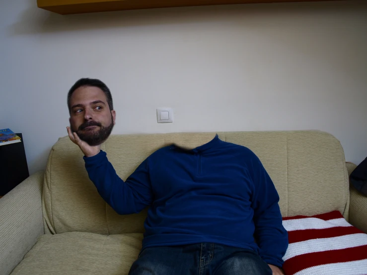 man sitting on couch with arm in air above head