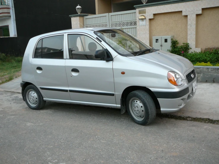 a small car parked next to a building on a street