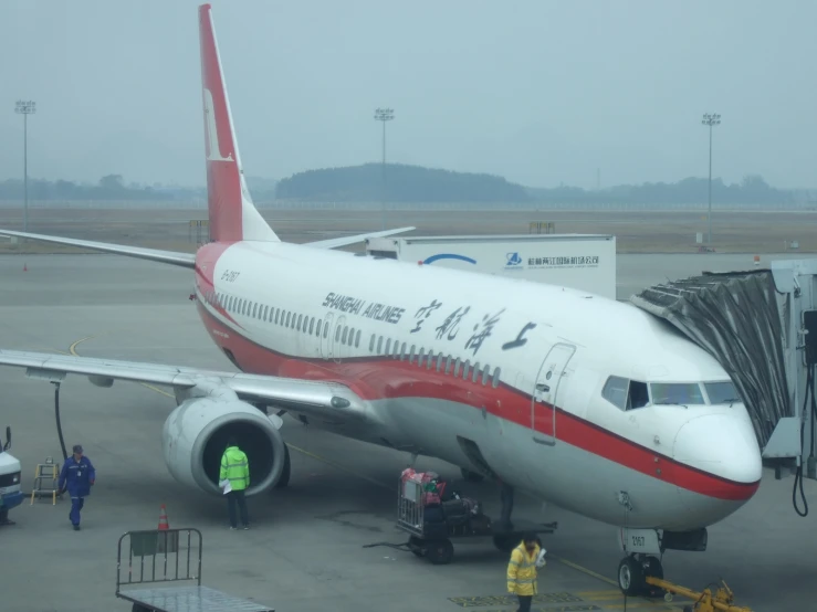 a china airlines airplane with writing on it parked at an airport gate