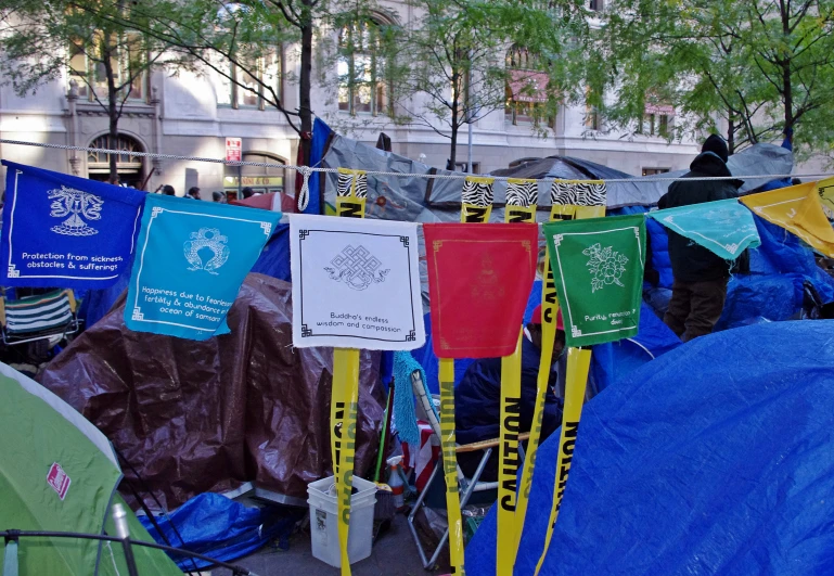 several tents are parked in the street with poles holding out signs