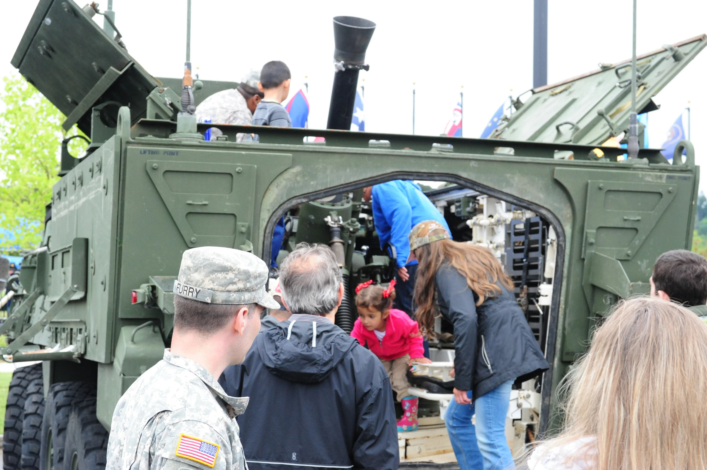 many people standing on the back of an army vehicle