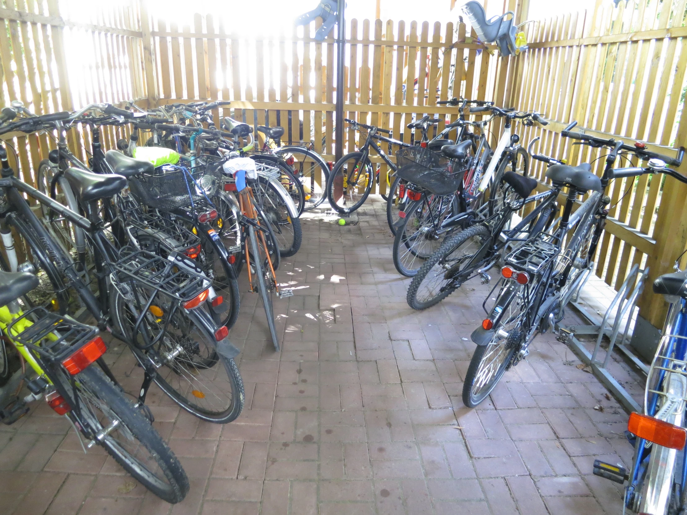 many bikes are shown against a wooden fence