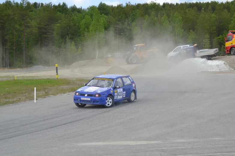 two vehicles on a race track in front of one another