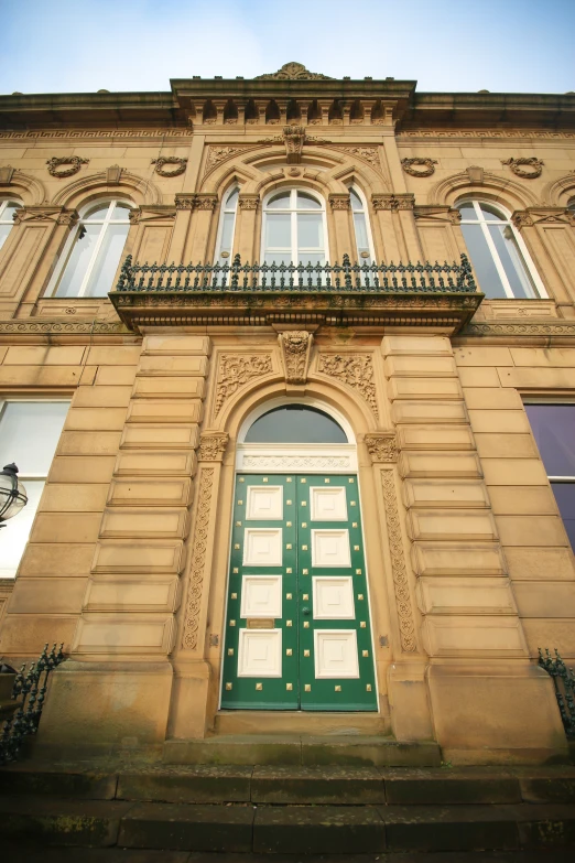 an old building is painted green and white