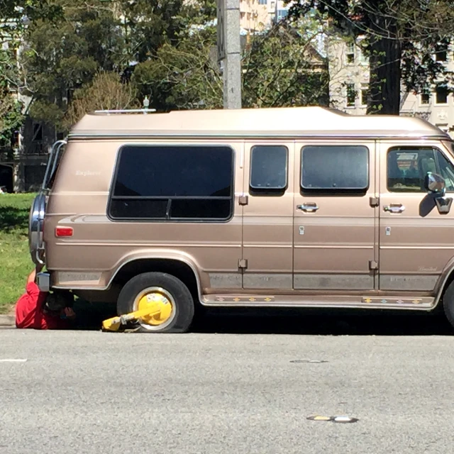 a very well made brown van is parked on the street