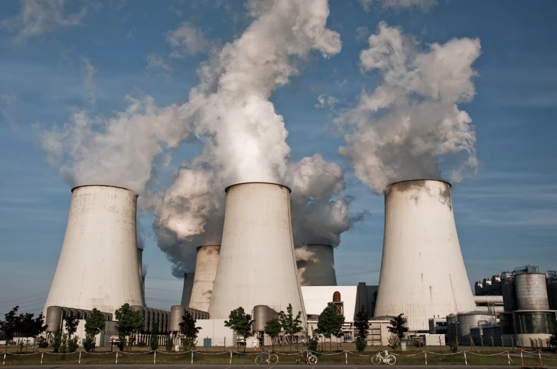 several smoke stacks rise above a city like area