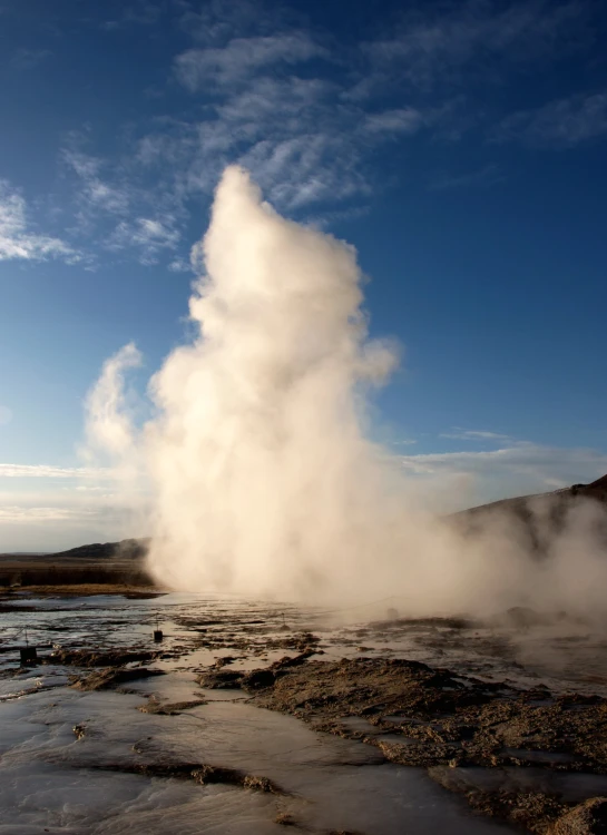 a geyser coming from a pond in a mountain