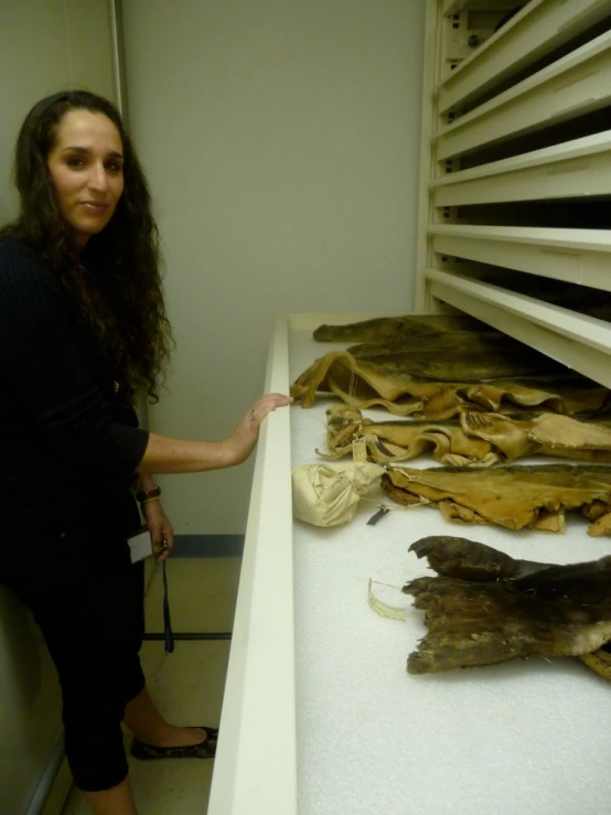 woman in a room with pieces of old clothing on display