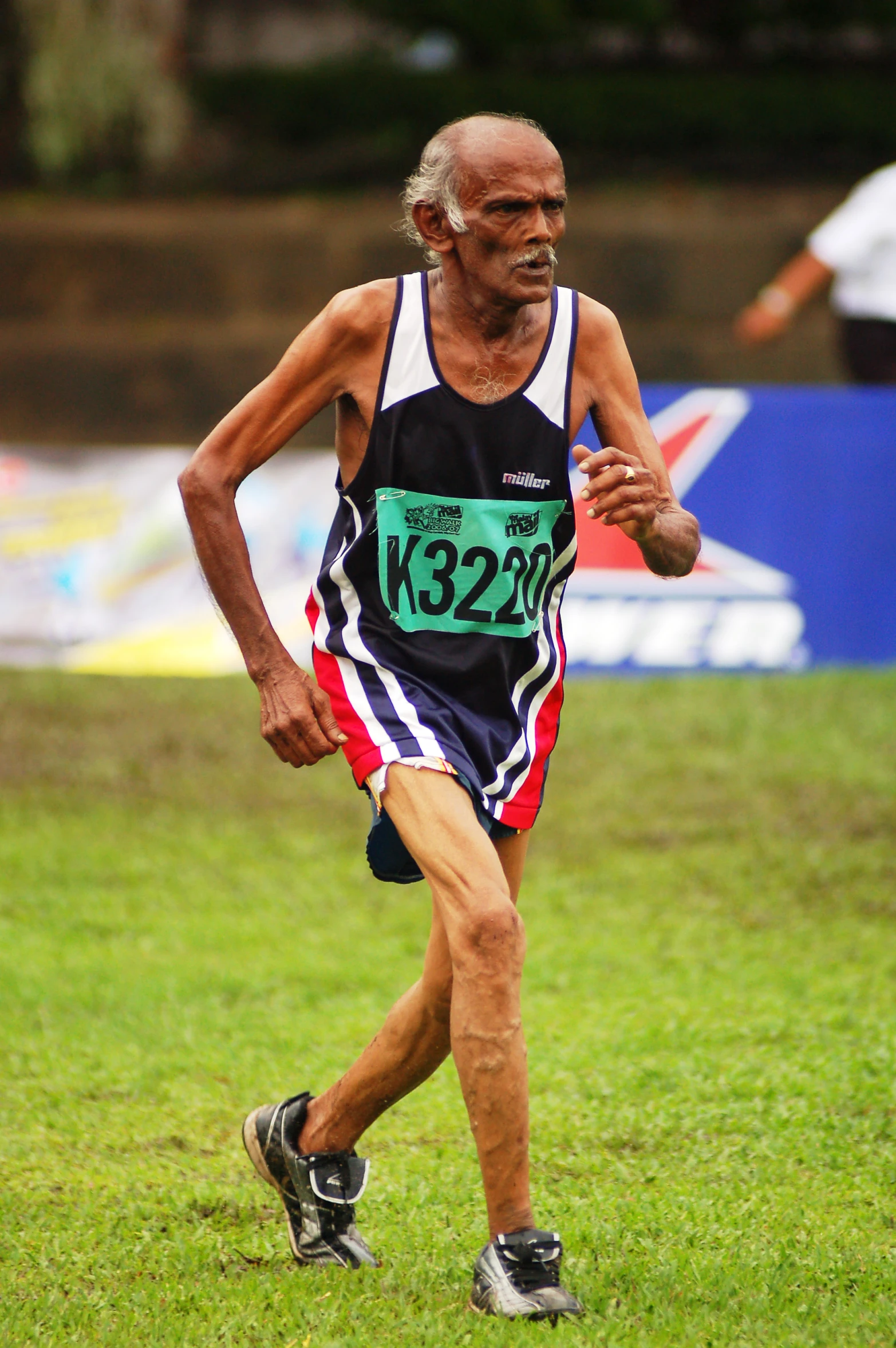 a man runs in a marathon across grass