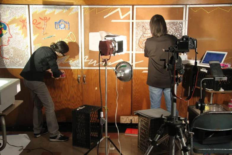 two people working in a television studio behind pography equipment