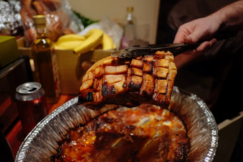 someone holds up a large piece of food on a silver plate