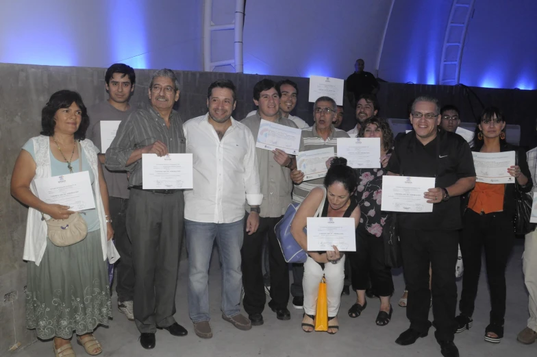 a group of people hold up letters of paper in front of the camera