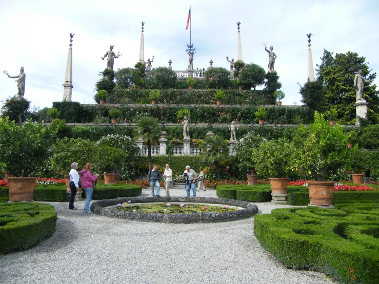 people walking around in an area made of hedges