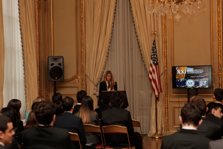 a person giving a speech with a large crowd