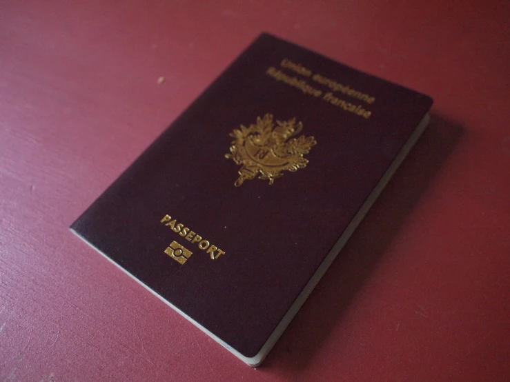 an australian passport sitting on top of a pink table