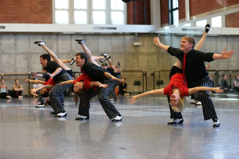 several dancers are performing a trick in a dance studio