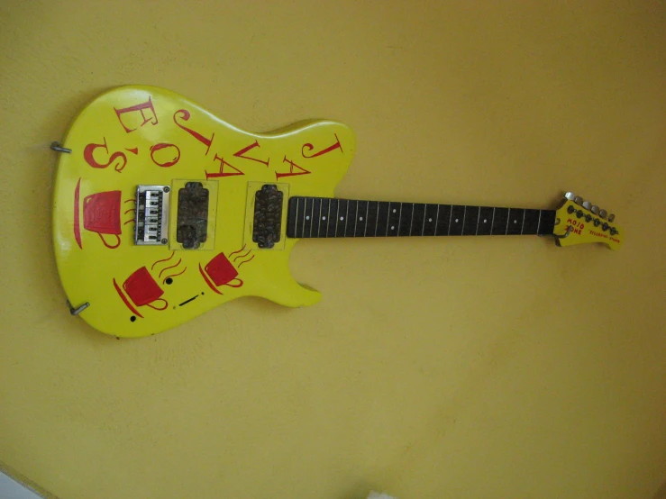 a yellow guitar is on display with some letters on it