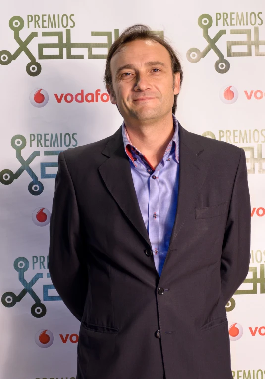 a man standing in front of a poster and smiling