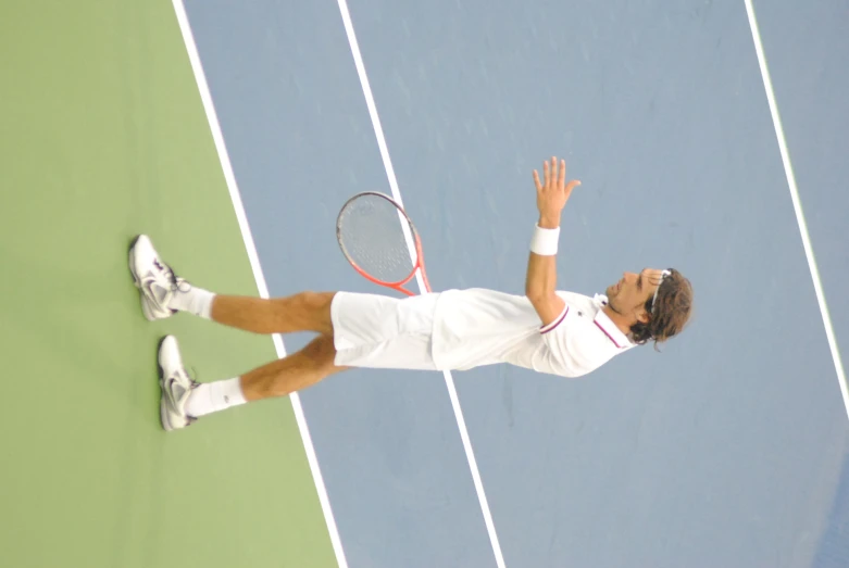 a man on a tennis court holding his racket up in front of him