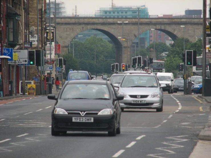 a couple of cars stopped at a traffic light on a street