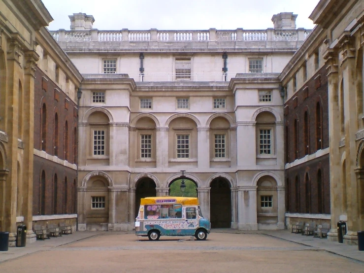 a vehicle is parked in a courtyard with many archways